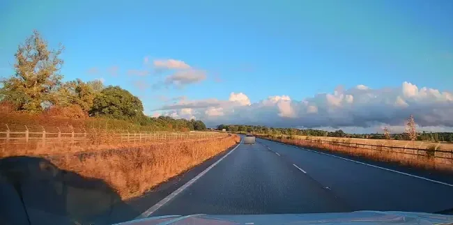 An open dual carriageway under a blue sky with light cloud
