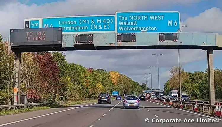 M6 Junction 8 gantry with a journey-time sign reading To J4A 16 mins, and signs for London (M1 and M40), Birmingham, Walsall, Wolverhampton and the North West